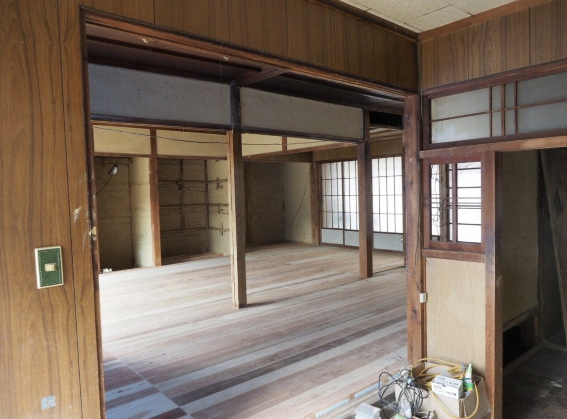 床張りを終えた古民家の広間 — 杉板の床と建具が整った改修後の室内